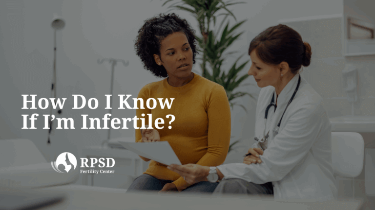 A thoughtful woman sitting on a couch, considering possible signs of infertility and seeking guidance from RPSD fertility specialists in San Diego.